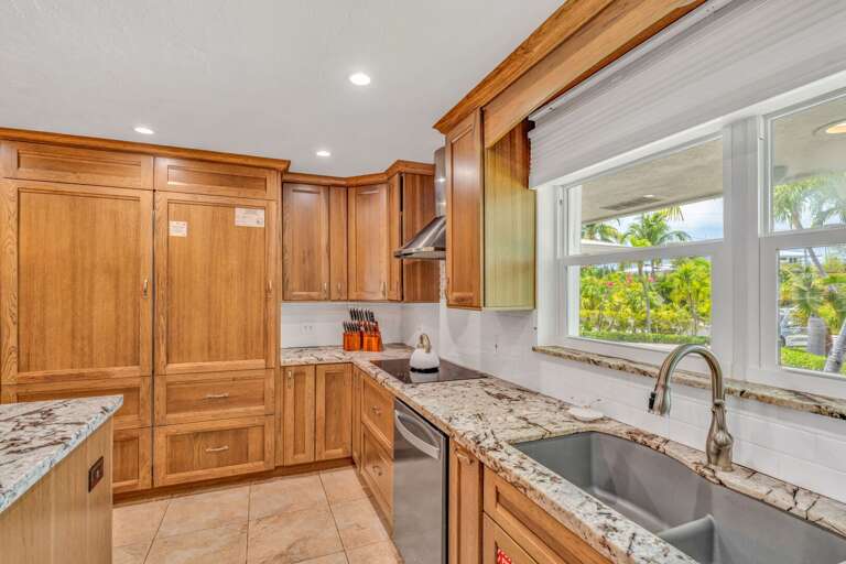 Gourmet kitchen in a Marathon vacation rental home with views of the private pool and tropical outdoor entertaining space. Gourmet kitchen in a Marathon vacation rental home with views of the private pool and tropical outdoor entertaining space.