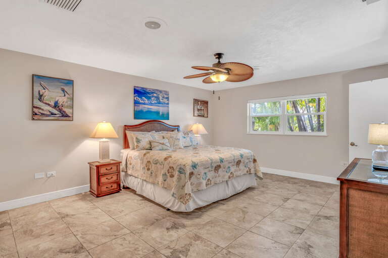 Luxury Florida Keys vacation rental master bedroom with large TV, built-in speakers, closet space, and serene waterfront views. Luxury Florida Keys vacation rental master bedroom with large TV, built-in speakers, closet space, and serene waterfront views.