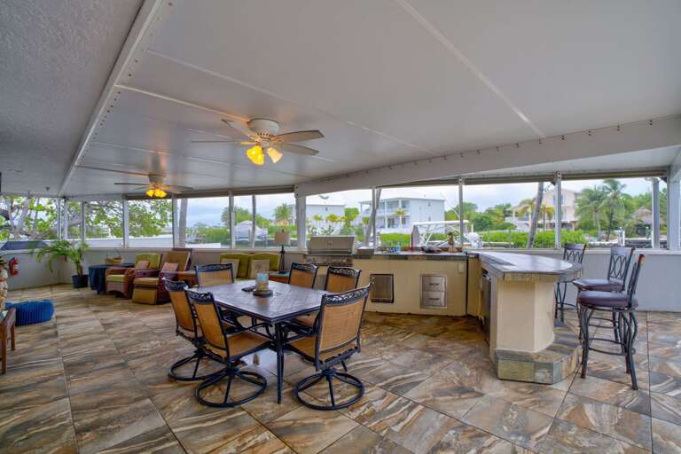 Spacious outdoor dining area with seating for the whole group, located poolside with water views in the Florida Keys.125-Foot Dock with Power and Water – Marathon FL Vacation Rental Spacious outdoor dining area with seating for the whole group, located poolside with water views in the Florida Keys.125-Foot Dock with Power and Water – Marathon FL Vacation Rental