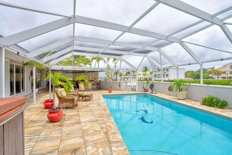 Spacious pool and spa area with screened enclosure and ambient lighting, perfect for entertaining at a Florida Keys vacation rental. Spacious pool and spa area with screened enclosure and ambient lighting, perfect for entertaining at a Florida Keys vacation rental.