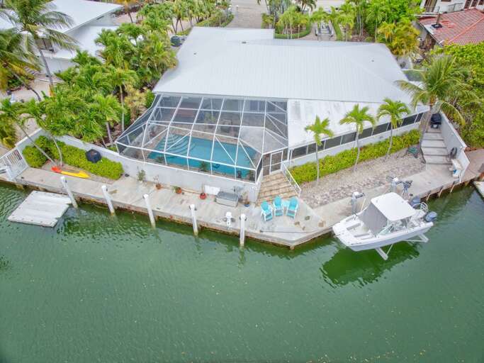 Stunning aerial of luxury Florida Keys vacation home featuring private pool, hot tub, and 125' dock in Marathon FL. Stunning aerial of luxury Florida Keys vacation home featuring private pool, hot tub, and 125' dock in Marathon FL.