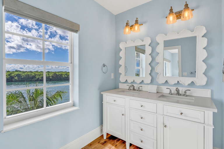 Bright and modern, this Florida Keys vacation home master bathroom offers privacy, luxury, and comfort with sweeping water views.
