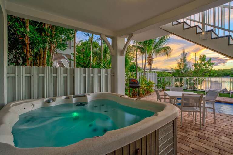 Enjoy a serene soak while watching the sun set over the water at this Florida Keys vacation home, offering ultimate comfort and privacy.