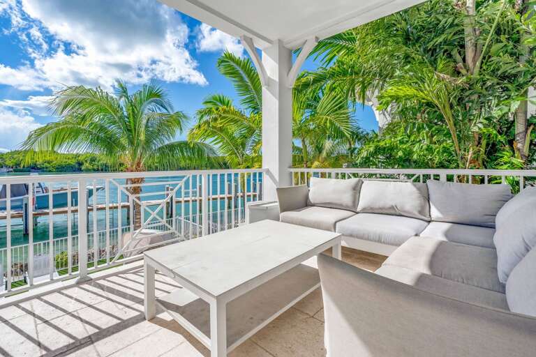 Enjoy sunrise and sunset over Vaca Cut from this private balcony, offering outdoor dining and lounge seating in this luxury Florida Keys vacation rental.