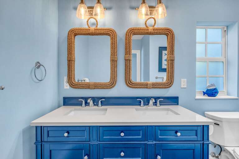 Functional and stylish, this third-level bathroom features dual sinks, a shower/tub combo, and coastal-inspired finishes for families or groups.