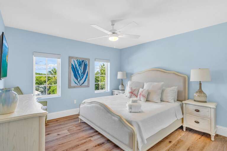 Relax in this elegant Florida Keys vacation home bedroom with a king bed, Smart TV, blackout shades, and water views—perfect for families or groups.