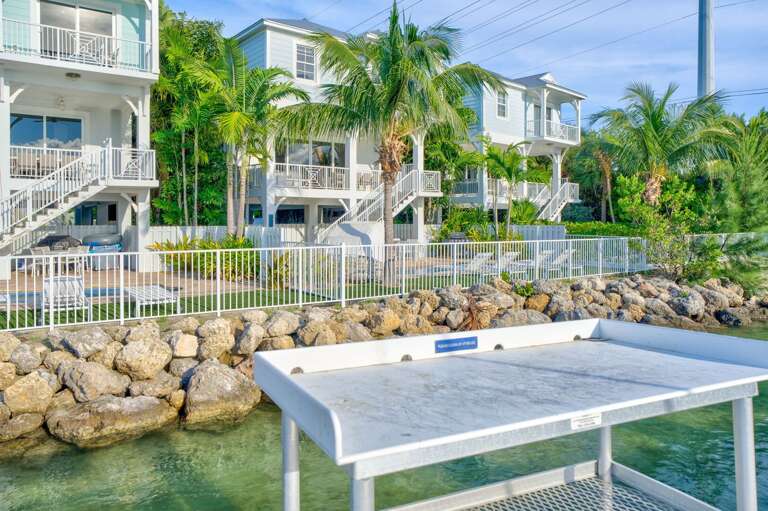 Relax in style at this luxury Marathon FL home, designed for entertaining with multiple outdoor seating and dining areas overlooking the water.