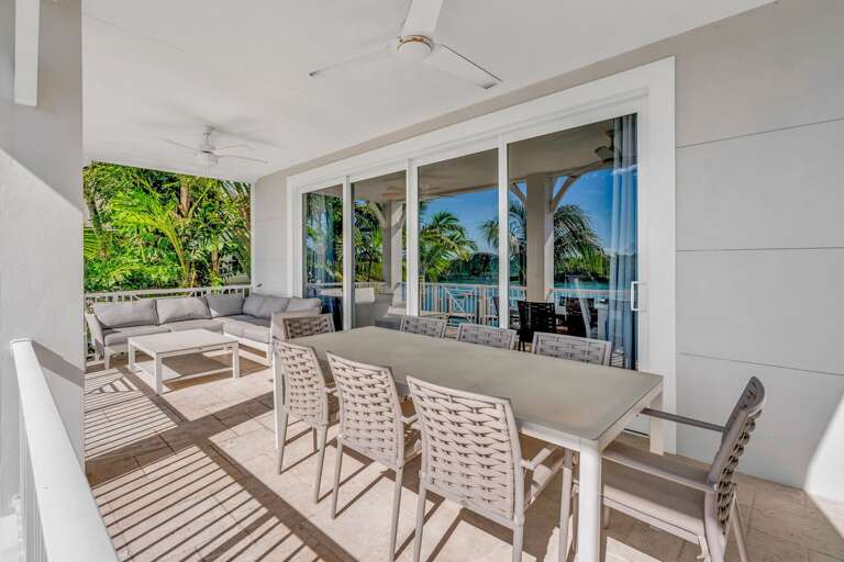 Relax with unobstructed water views from the balcony of this Marathon FL vacation rental, featuring cozy seating and a tranquil waterfront setting.