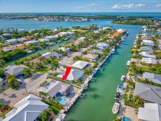 Drone shot of Key Colony Beach Florida Keys vacation rental showing canal and private boat dock leading to the Atlantic Ocean. Drone shot of Key Colony Beach Florida Keys vacation rental showing canal and private boat dock leading to the Atlantic Ocean.