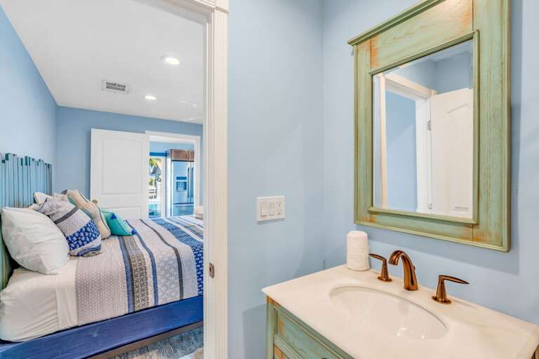 King bedroom ensuite bathroom with tropical-inspired decor in Key Colony Beach Florida Keys rental home. King bedroom ensuite bathroom with tropical-inspired decor in Key Colony Beach Florida Keys rental home.