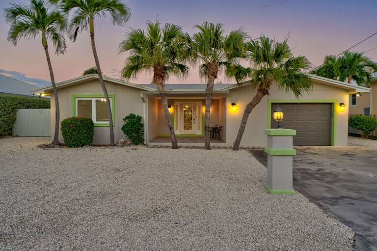 Nighttime exterior view of Key Colony Beach Florida Keys waterfront vacation rental with tropical lighting. Nighttime exterior view of Key Colony Beach Florida Keys waterfront vacation rental with tropical lighting.