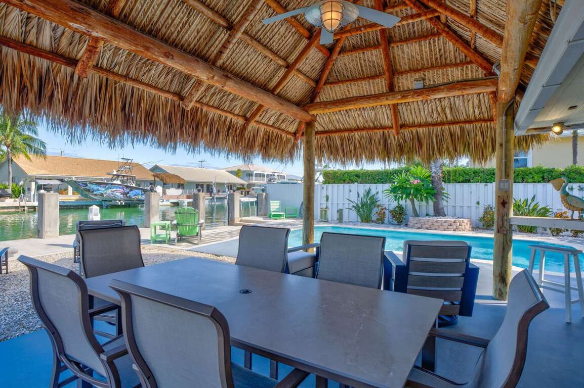 Outdoor dining table with water views at Key Colony Beach Florida Keys luxury rental home. Outdoor dining table with water views at Key Colony Beach Florida Keys luxury rental home.
