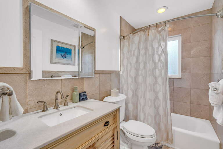 Shared hall bathroom with shower/tub combo and coastal design at Key Colony Beach Florida Keys vacation home. Shared hall bathroom with shower/tub combo and coastal design at Key Colony Beach Florida Keys vacation home.