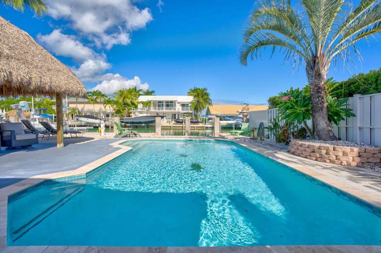 Tropical pool deck with seating and waterfront views in Key Colony Beach, Florida Keys vacation rental. Tropical pool deck with seating and waterfront views in Key Colony Beach, Florida Keys vacation rental.