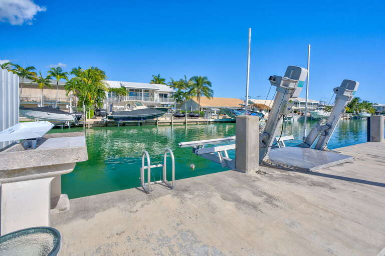 Waterfront dock with boat lift at luxury Key Colony Beach Florida Keys vacation rental home. Waterfront dock with boat lift at luxury Key Colony Beach Florida Keys vacation rental home.