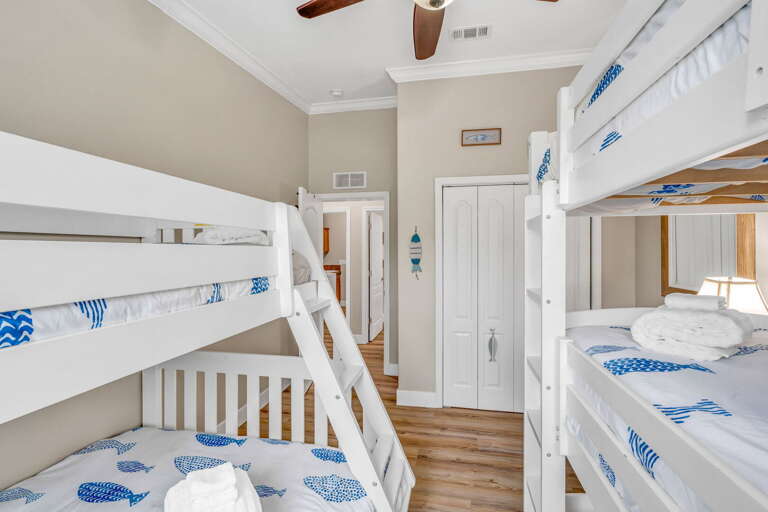 A bright, beach-inspired bunk room offering the perfect setup for children, complete with cozy bedding and family-friendly layout.