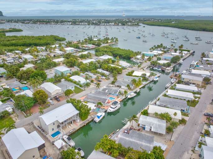 Elevated shot emphasizing the home's canal-front location, private dock, and seamless Atlantic access for boating and water sports.