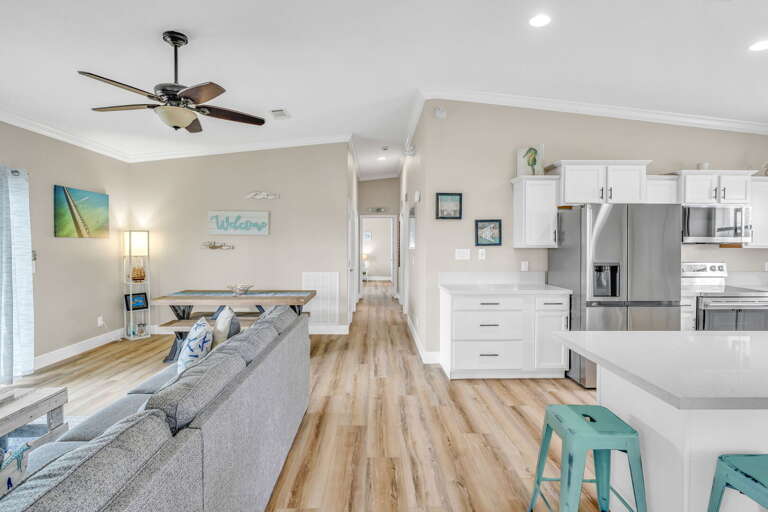 Spacious open-concept layout combining living and dining areas, featuring tropical décor and unobstructed canal views in Marathon, FL.