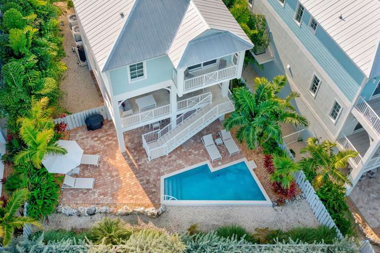 Bird's-eye view showcasing a premium waterfront property with pool, lanai, and boat slip leading directly to the Gulfside—ideal for boating, fishing, and family vacations in the Florida Keys.
