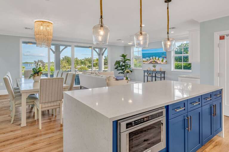 Bright open-concept kitchen with island seating and designer finishes—steps from your private pool