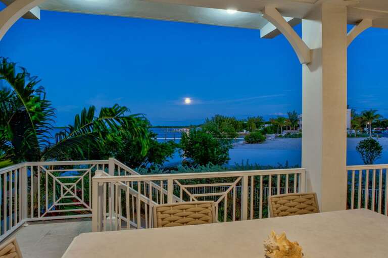 Cozy and inviting night scene of the outdoor balcony area, showcasing the Florida Keys' magical moonlit ambiance for couples and families.
