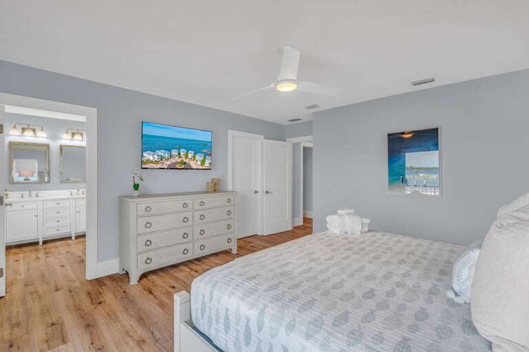 Elegant master bedroom featuring spa-style ensuite bath and high-end furnishings in a luxury water-front home close to the Gulf of America.