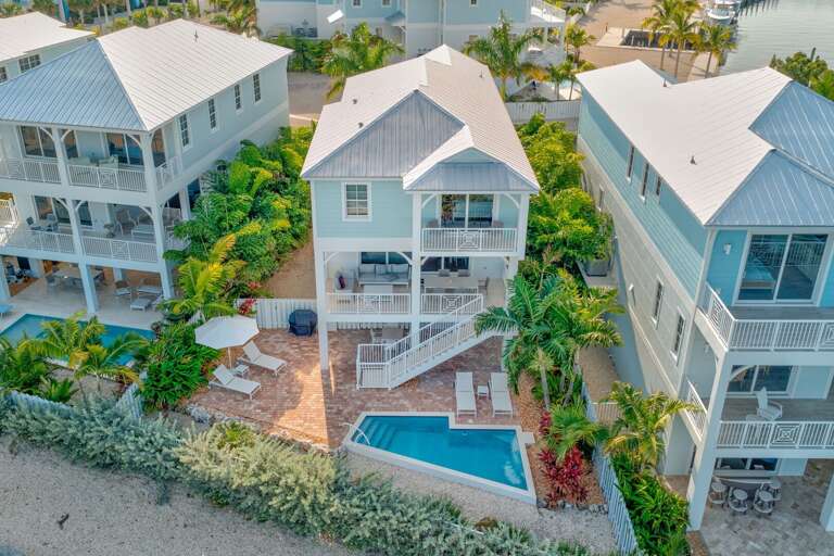 Elegant waterfront home with heated pool, sundeck, and high-end outdoor lounge spaces. Located in a desirable private community for a peaceful, luxurious vacation experience.