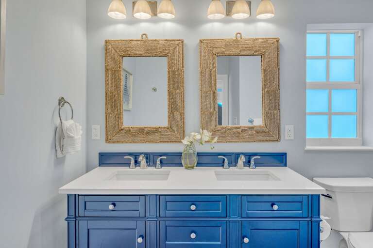 Large shared hall bath with dual sinks, stylish fixtures, and breezy Florida Keys coastal accents—perfect for guest convenience in upscale Marathon FL waterfront rentals.
