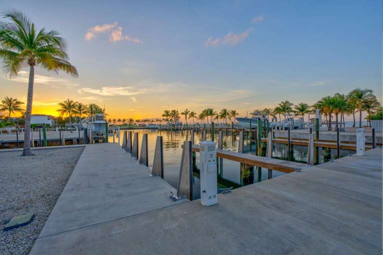 Spacious and secure community dock with a reserved boat slip, perfect for families and groups staying at canal-front Florida Keys vacation rentals with private amenities.