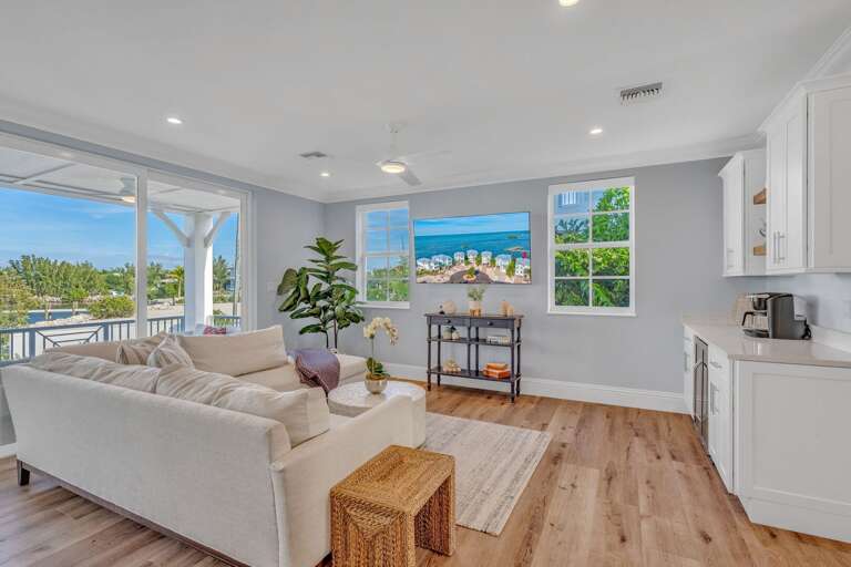 Stylish living room with modern furnishings in a water-front home featuring heated pool and outdoor seating.