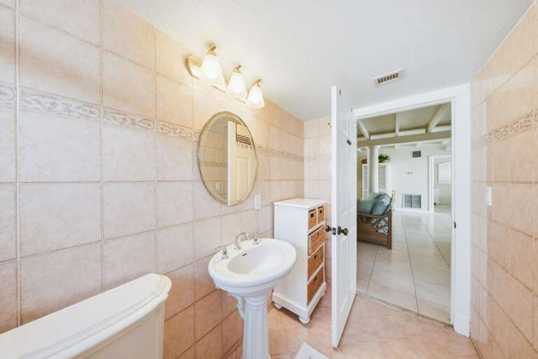 Family-friendly hall bathroom in a Marathon FL canal-front vacation rental with a shower/tub combo, perfect for group stays or multi-family vacations.