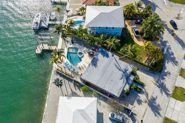 Incredible aerial shot of a luxury canal-front vacation home in Marathon FL with pool, dock access, and beautiful Florida Keys scenery.