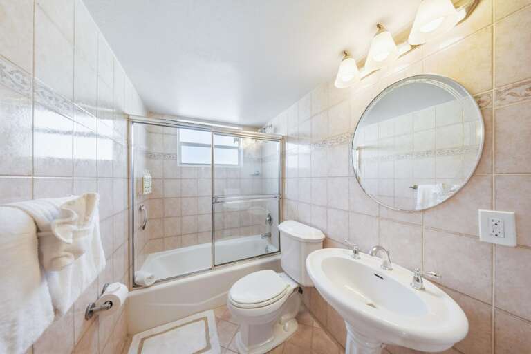 Spacious bathroom in a Marathon FL canal-front vacation home with combined shower and tub, ideal for kids or group use during your Florida Keys getaway.