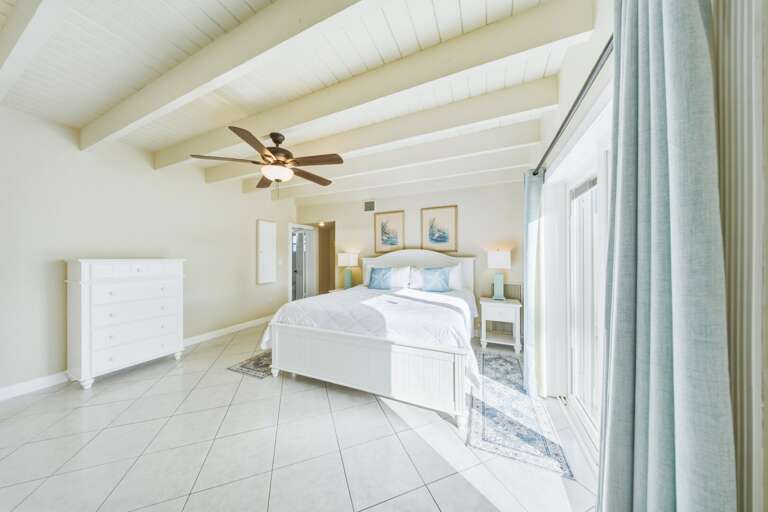 Spacious master suite in a Marathon Florida Keys canal-front vacation rental featuring relaxing water views and easy access to the private pool.