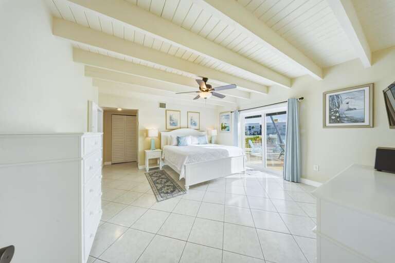 Spacious master suite in a Marathon Florida Keys canal-front vacation rental featuring relaxing water views and easy access to the private pool.