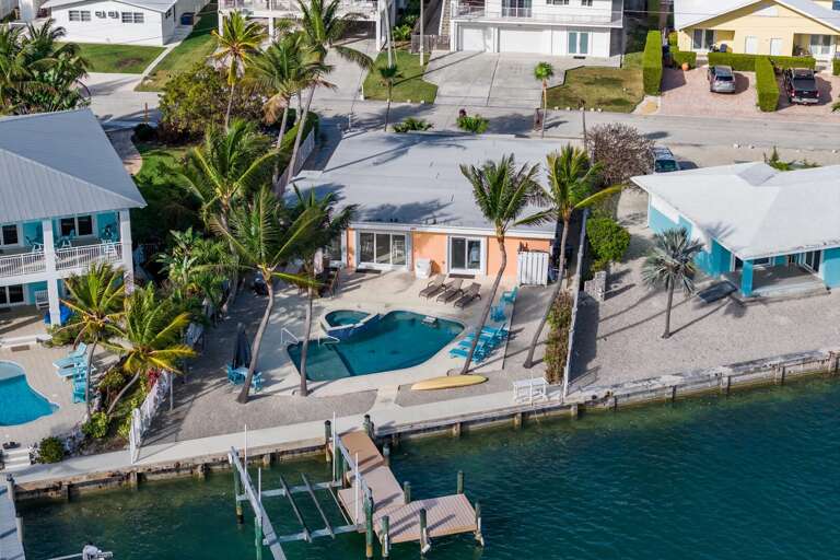 Stunning aerial view of a luxury Marathon Florida Keys waterfront vacation rental featuring a private pool, canal access, and tropical outdoor living.