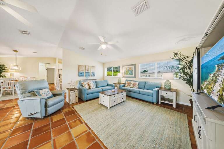 Coastal-inspired living room with large sliding glass doors leading to a screened balcony