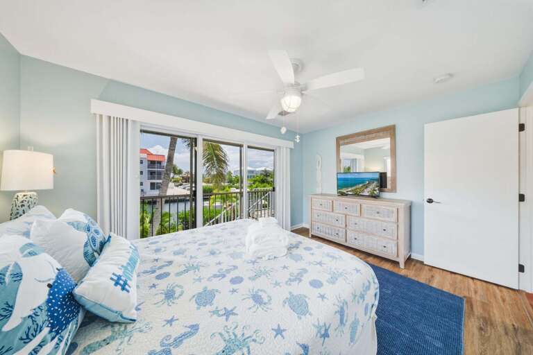 This inviting queen bedroom features private balcony access and a Smart TV, offering a comfortable