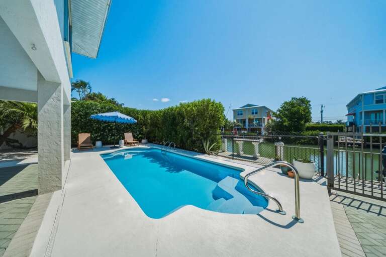 Relax by your private pool surrounded by lounge seating, perfect for soaking up the Florida sun just minutes from Sombrero Beach.