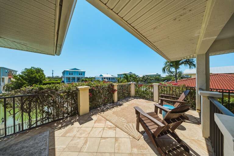 A welcoming front terrace with seating and tropical landscaping offers a peaceful place to relax at your Marathon FL Florida Keys getaway.