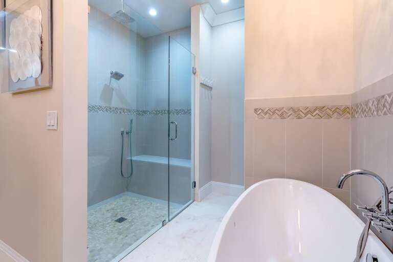 A spa-inspired bathroom featuring a freestanding soaking tub and a separate glass-enclosed walk-in shower.