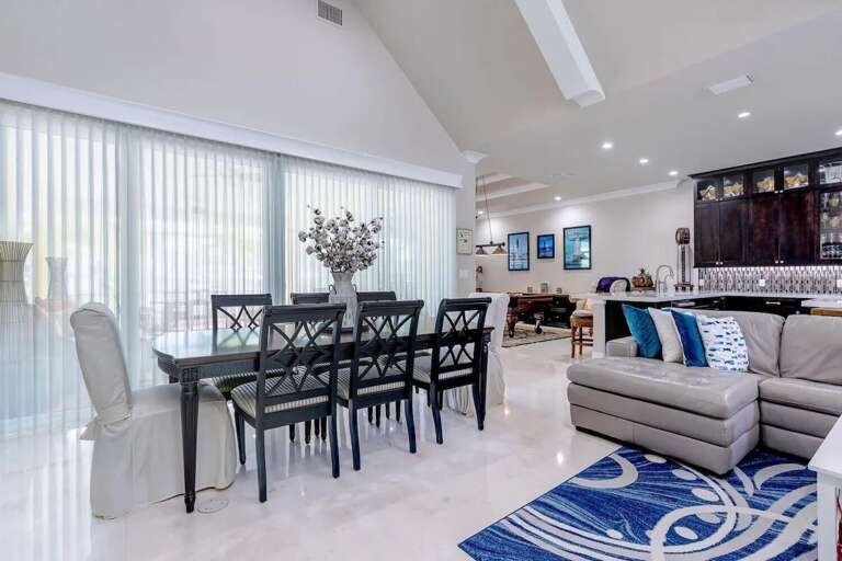A spacious dining table sits beside large windows in the bright, open-concept living area of this Marathon vacation rental.