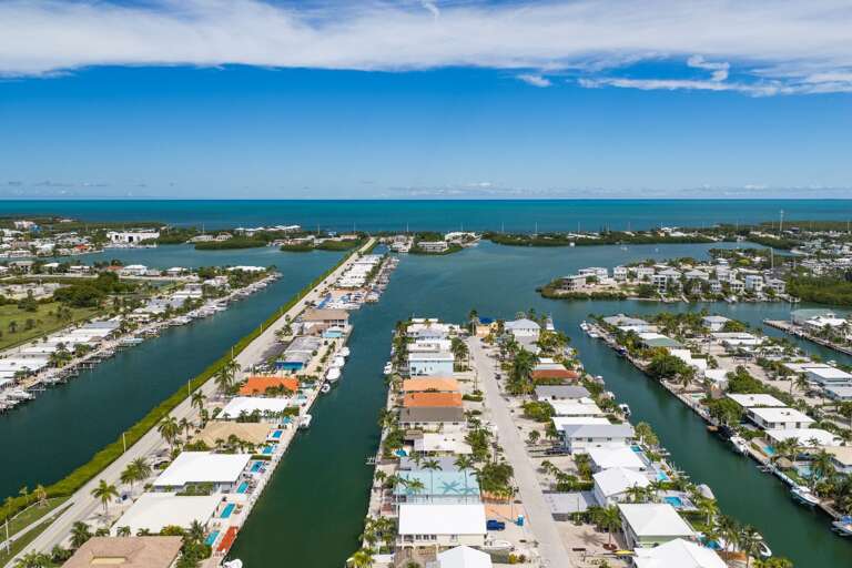 This sweeping aerial perspective captures Marathon's canal network, waterfront homes, marina areas, and the nearby Atlantic Ocean.