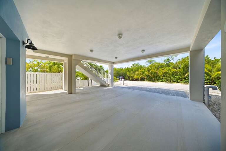 A wide covered area beneath the home provides sheltered parking and flexible space for storing vacation and boating gear.