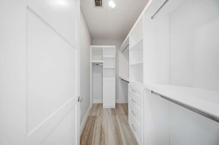 A large walk-in closet provides ample shelving and hanging space for clothing, luggage, and vacation essentials.