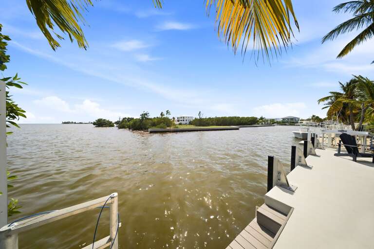 Steps lead directly into the water from the private dock, offering convenient access for swimming, paddling, or boating adventures.