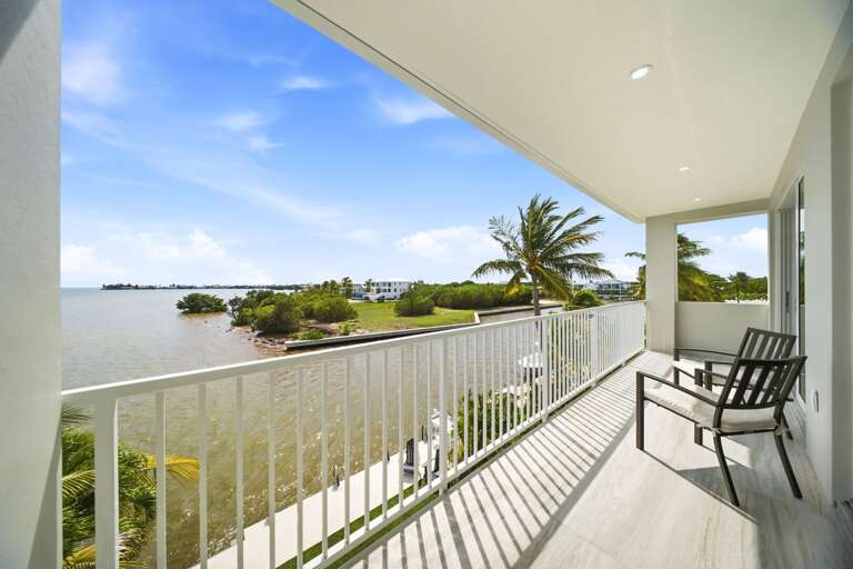 This shaded outdoor space offers seating, fresh coastal air, and relaxing views across the wide Marathon canal.