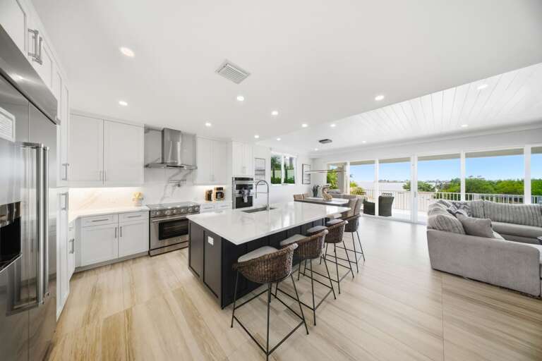 A bright open floor plan connects the modern kitchen and living room, creating an inviting space for meals and group gatherings.