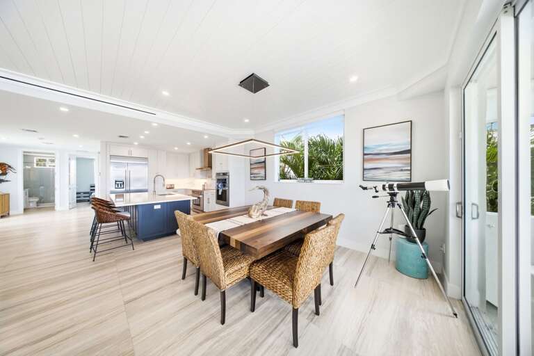 Gather around the large dining table in a bright coastal space that flows naturally into the kitchen and living room.