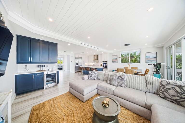 Relax in a stylish living space featuring sectional seating, a television, and a convenient built-in beverage bar.